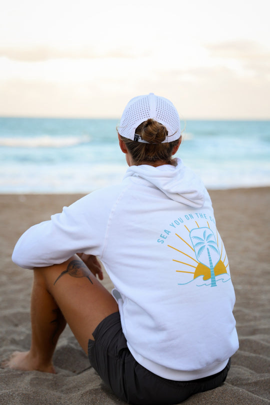 Court Side White Pickleball Hoodie, back print on the beach facing the ocean | The Pickled Palm