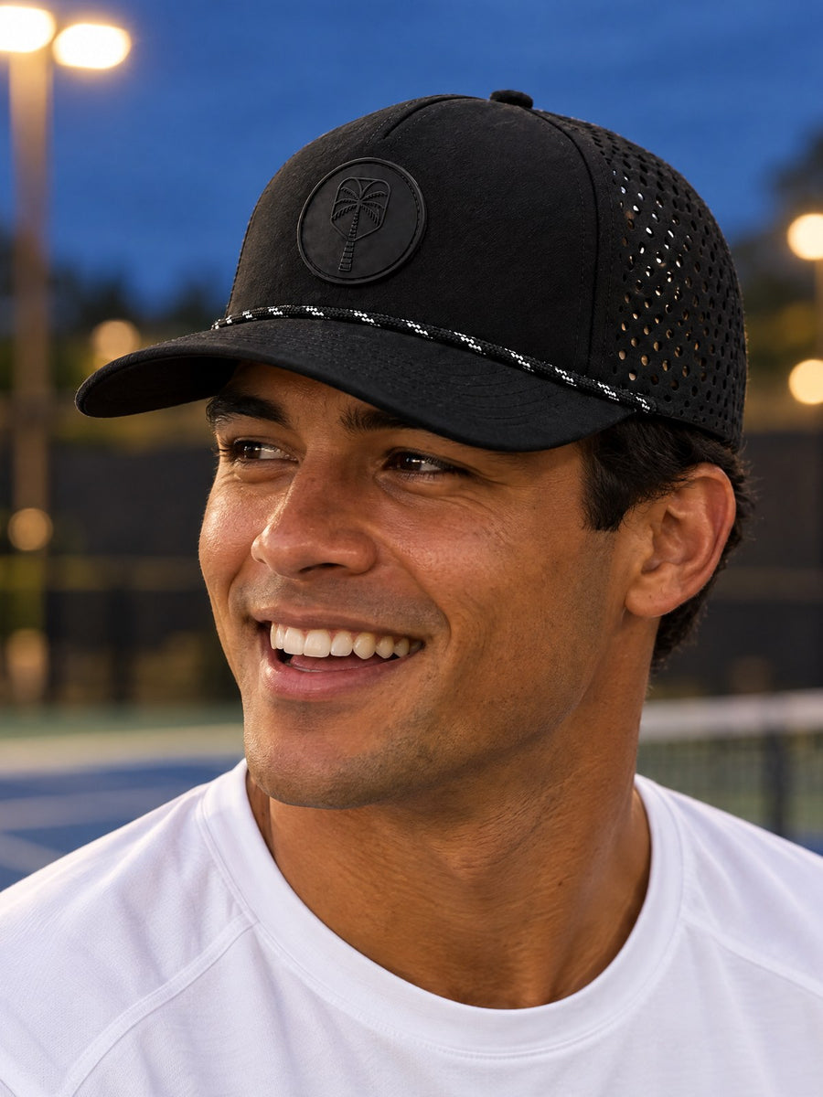 Close-up of The Late Night Rally black performance hat on a player at an evening pickleball court